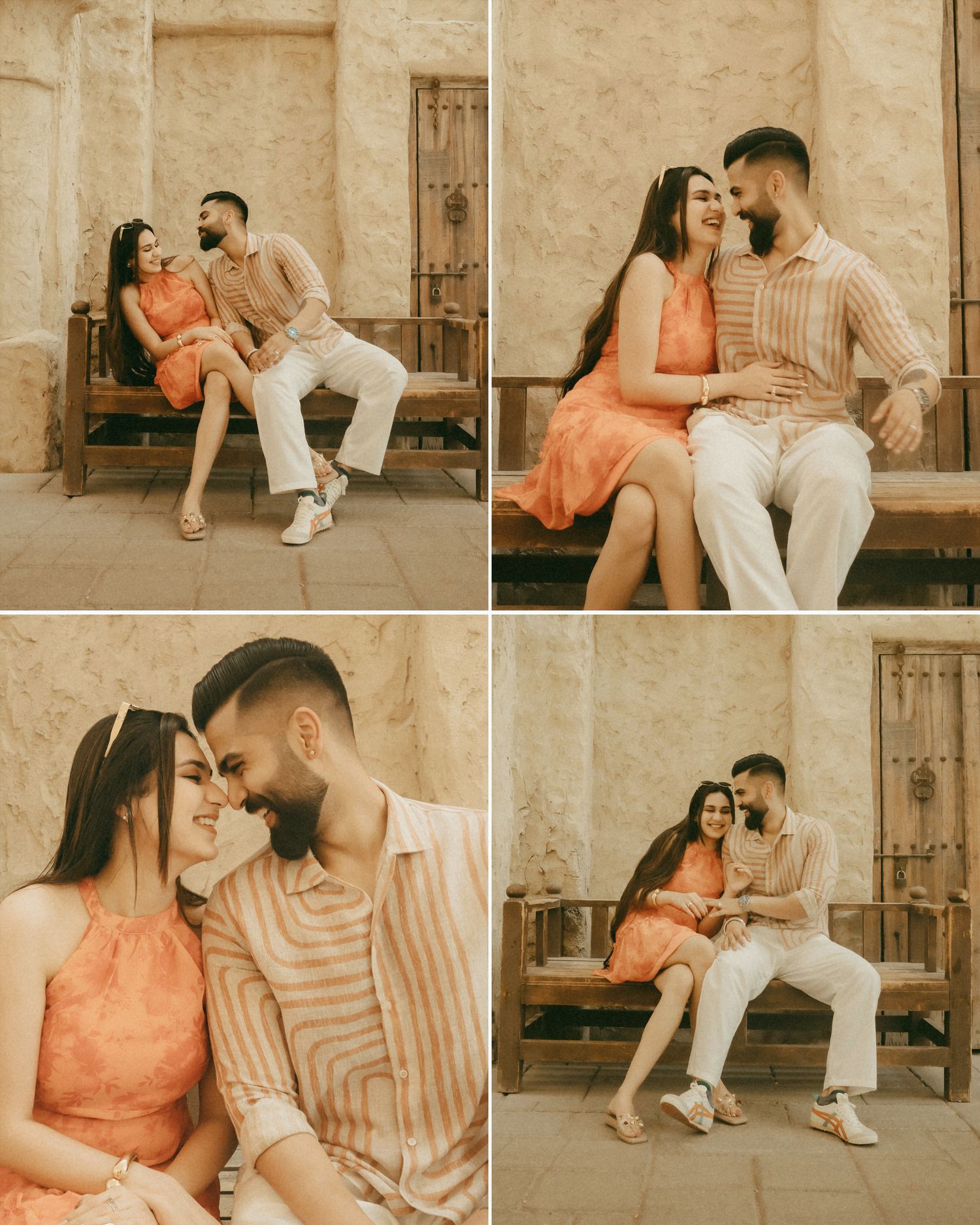Romantic couple in coordinating peach and striped outfits sitting on a wooden bench against a stone wall.
