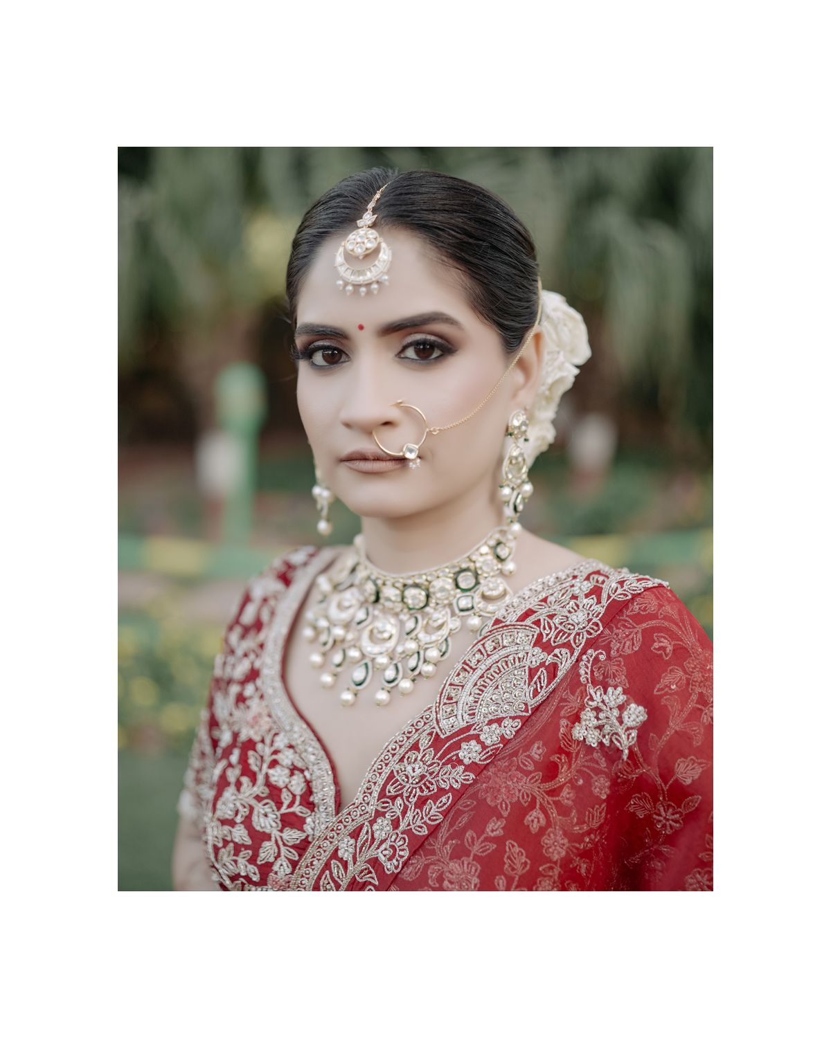 Close-up portrait featuring traditional bridal jewelry and makeup with a red dupatta.