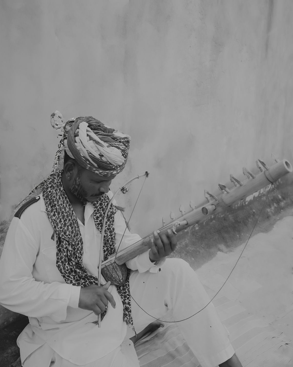 Vintage black and white photo of a musician playing a traditional string instrument.