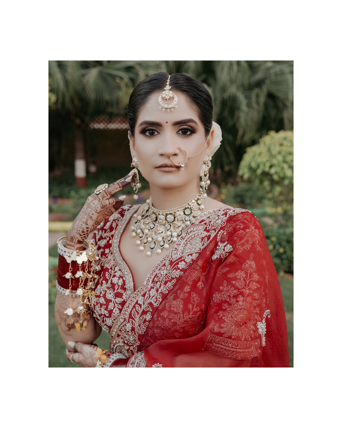 Close-up shot highlighting ornate bridal jewelry and detailed embroidery work on red attire.