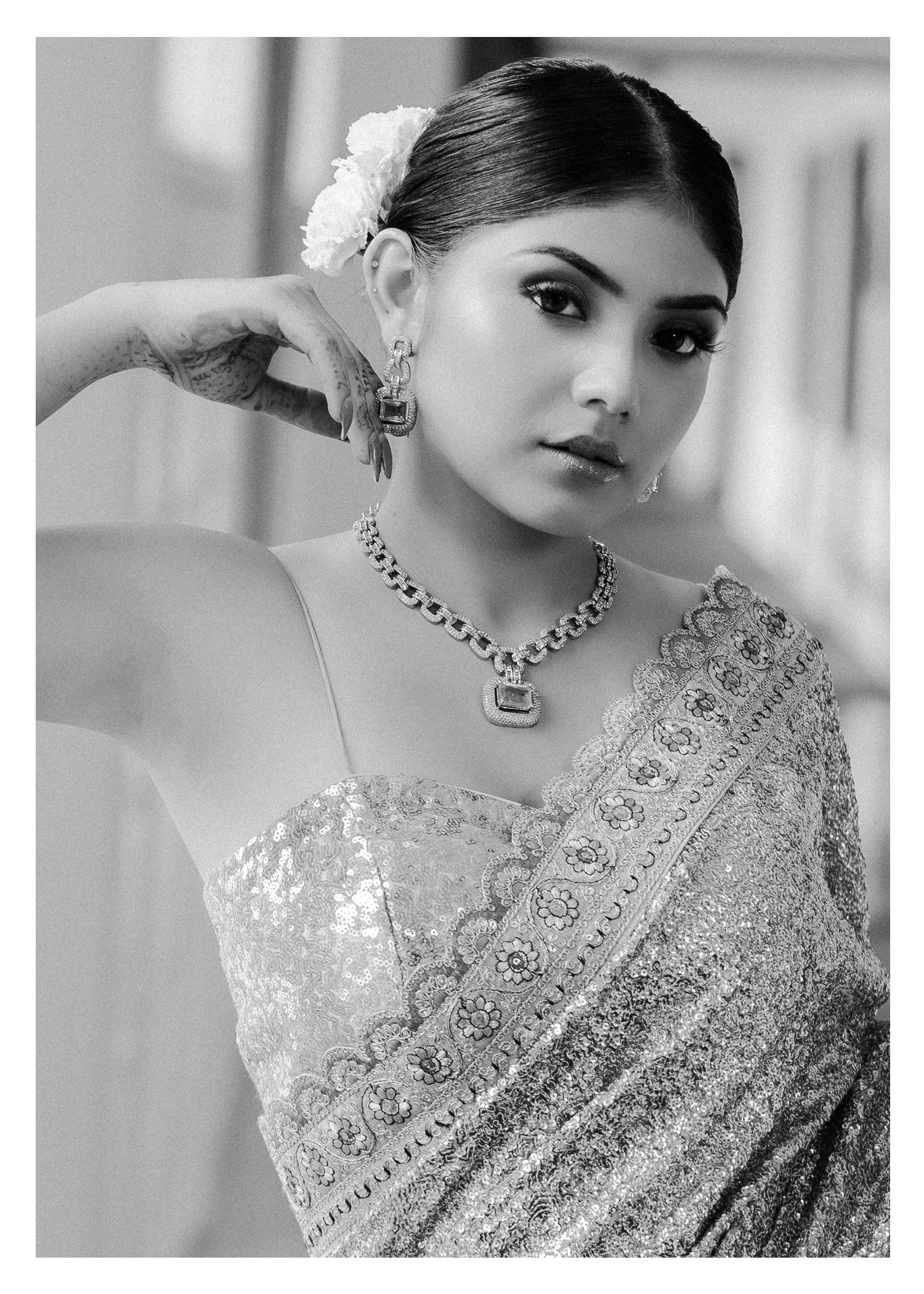 Traditional bridal look featuring an elegant embroidered silver saree with matching crystal jewelry in black and white.