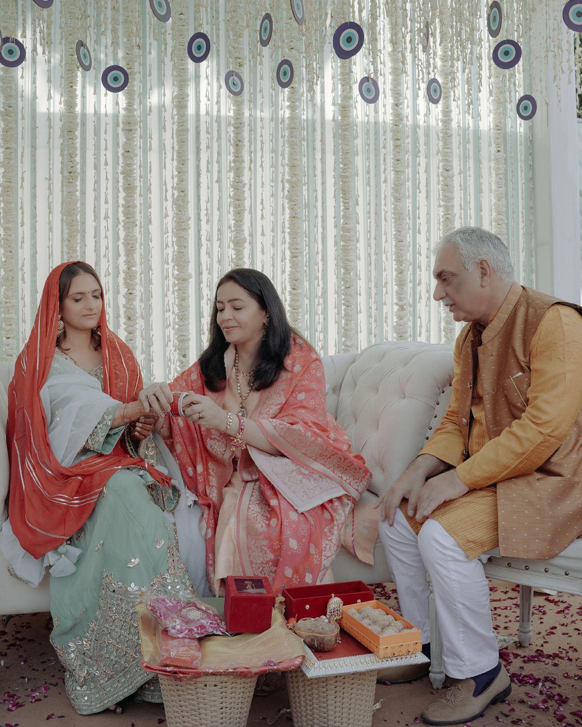 Wedding guests relaxing on a couch during traditional Indian celebration.