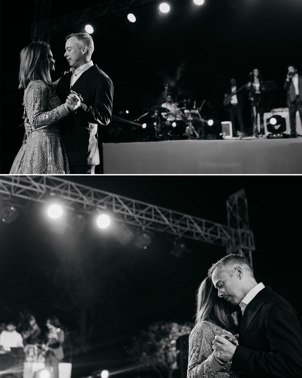 A couple shares an intimate dance moment under dramatic stage lighting at an outdoor event.