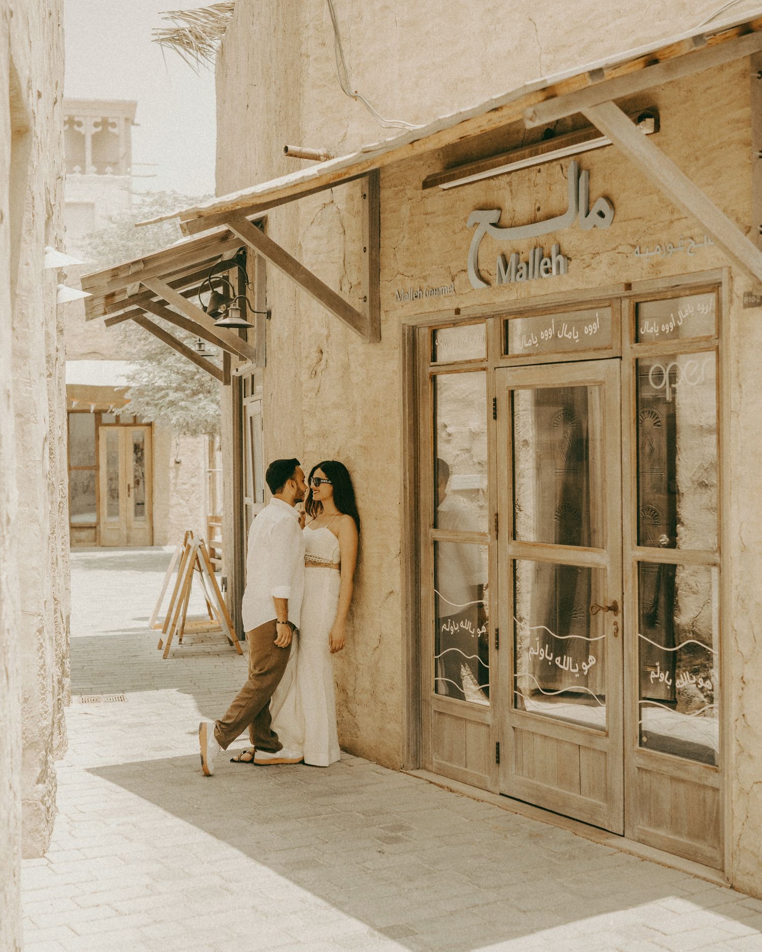 Couple sharing a romantic moment outside a rustic shop in Al Fahidi, Dubai's historic district.