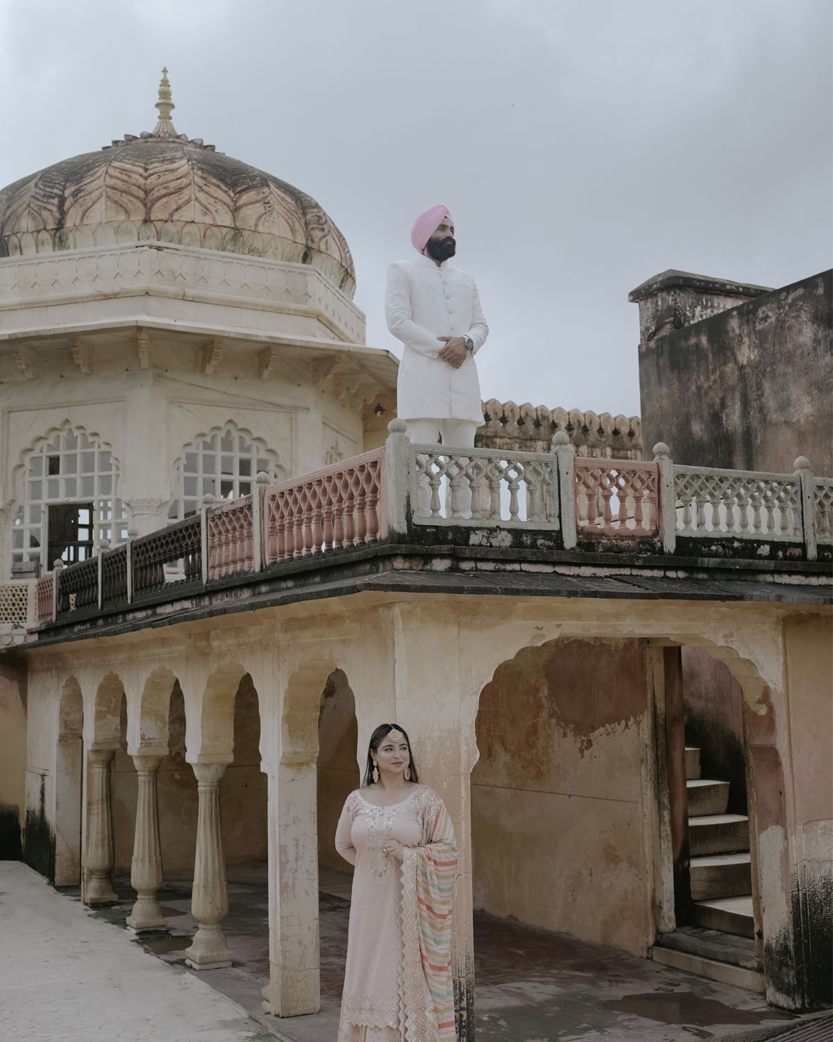 Historic Indian palace architecture featuring domed roof, arched walkway and ornate railings.