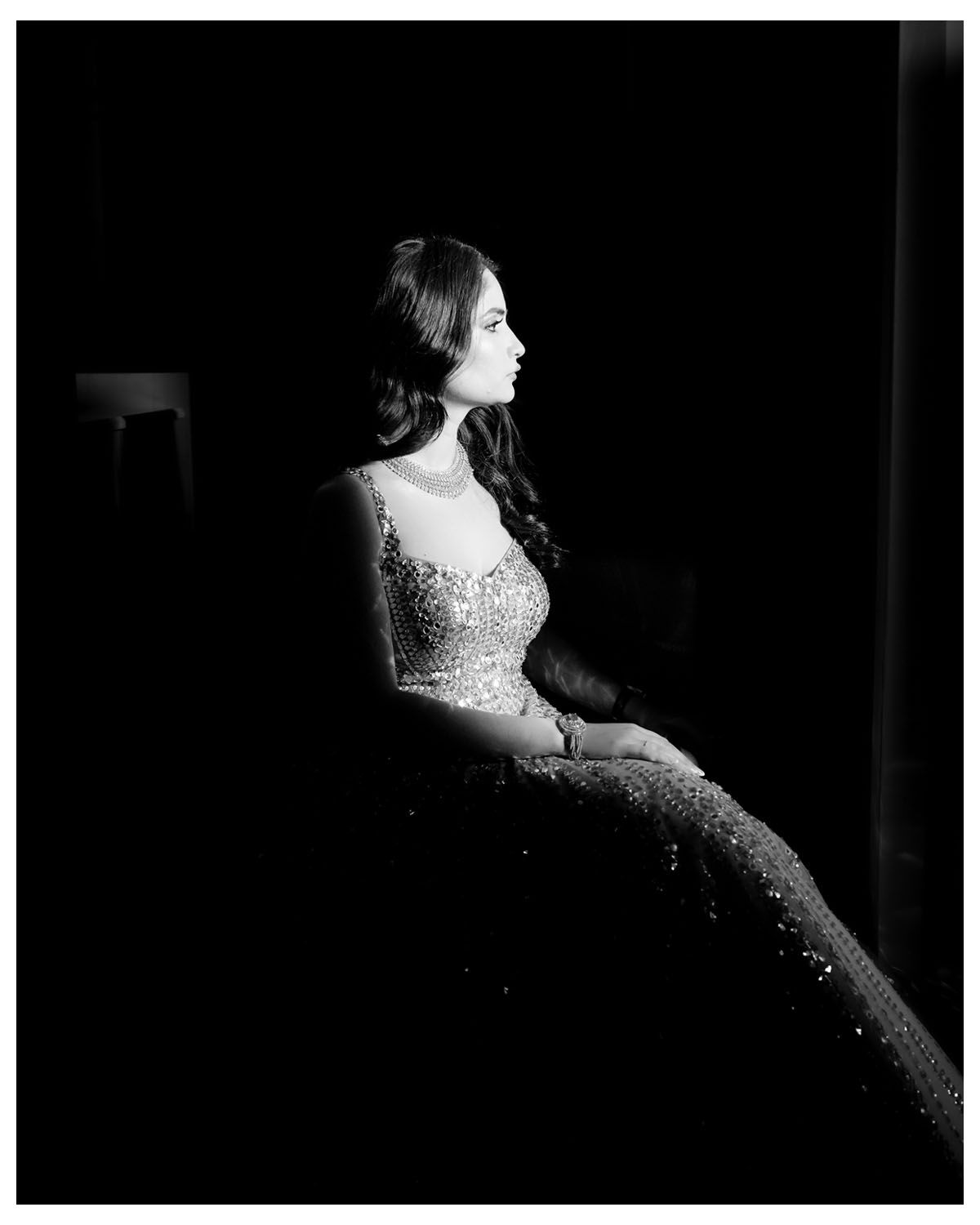 Dramatic black and white side profile of person in embellished ball gown.