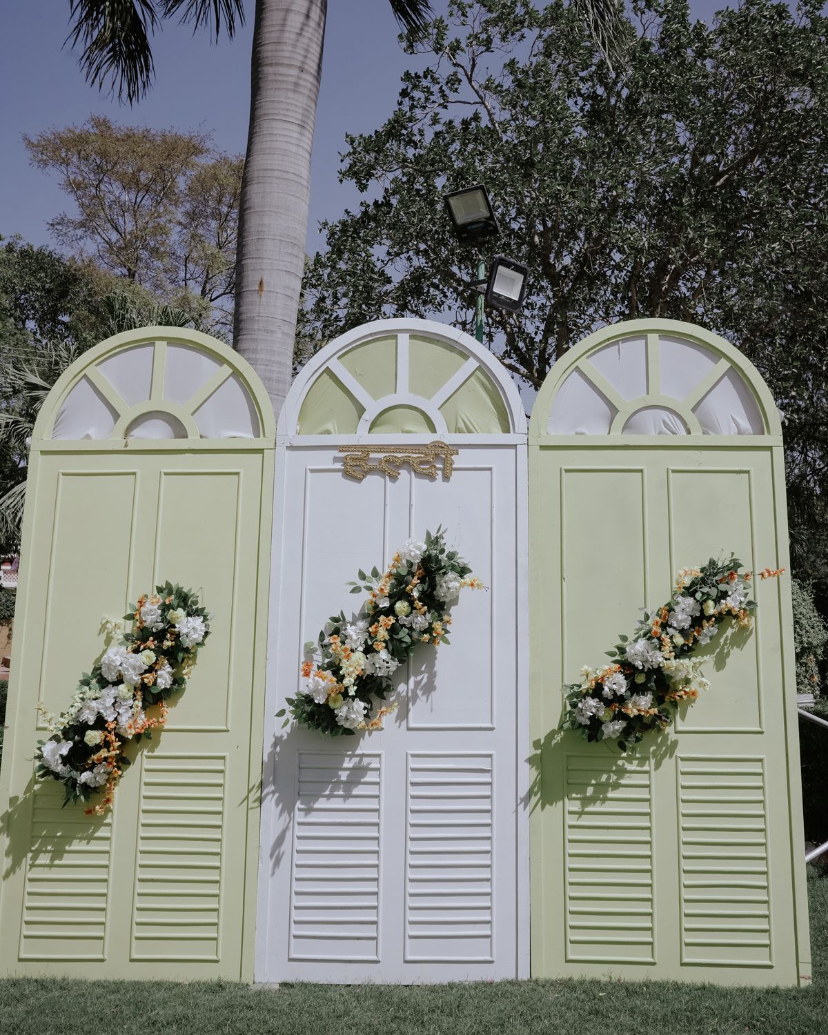 Decorative white and mint green wedding backdrop with floral arrangements.