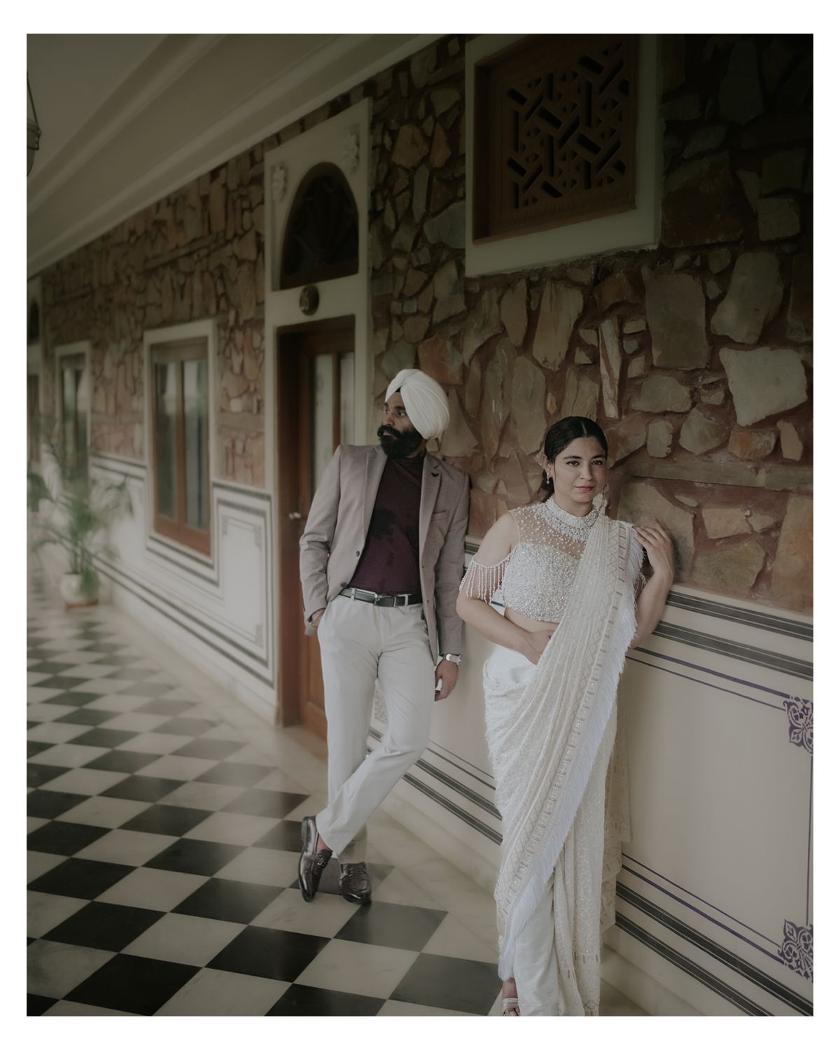 Fashion photo shoot in a hallway with checkerboard floor and stone wall details.