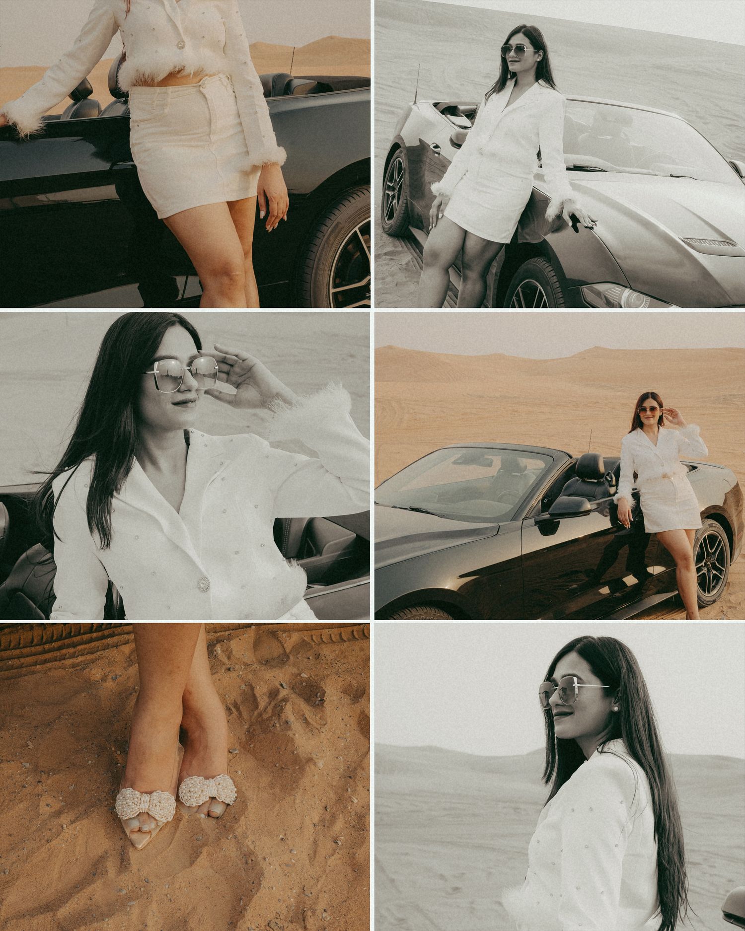 Woman in white blazer and skirt posing by a black sports car in the desert sand dunes.