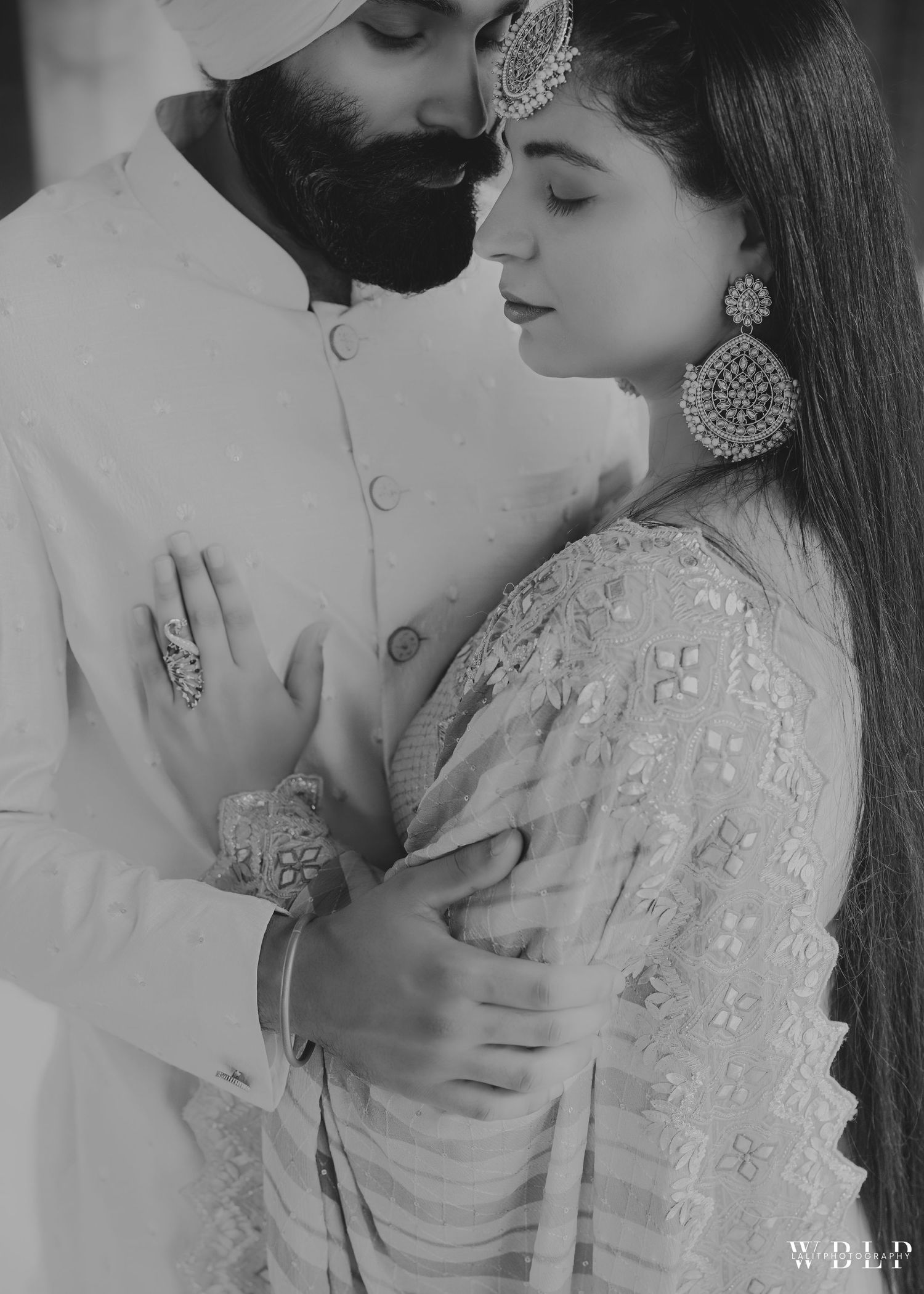 Black and white intimate portrait showcasing traditional Indian wedding attire and jewelry.