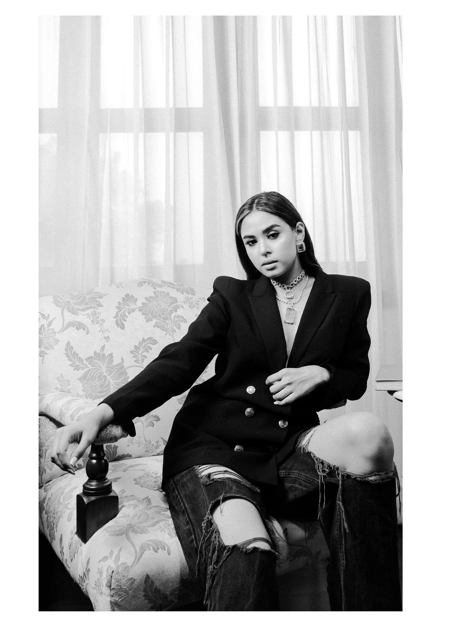 Four black and white artistic fashion photos showing moody poses against light curtained backdrop in formal attire.