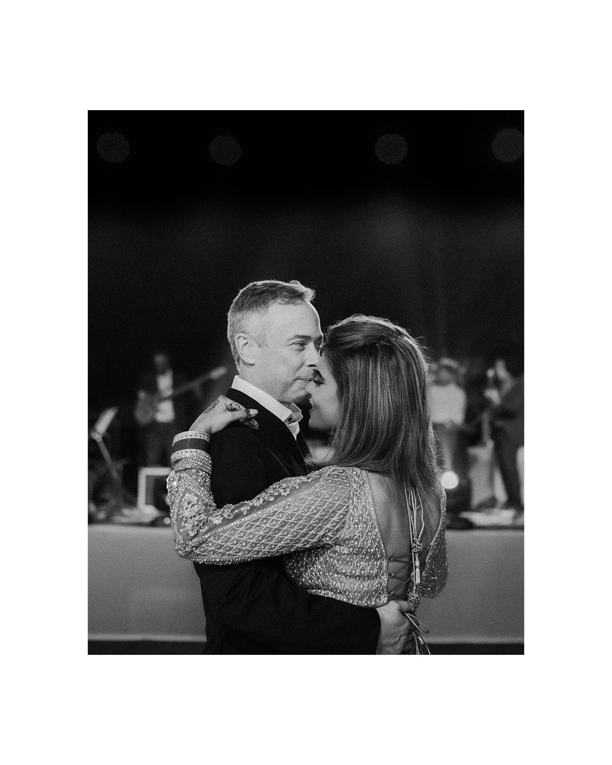 A romantic slow dance captured in black and white photography at an evening reception.