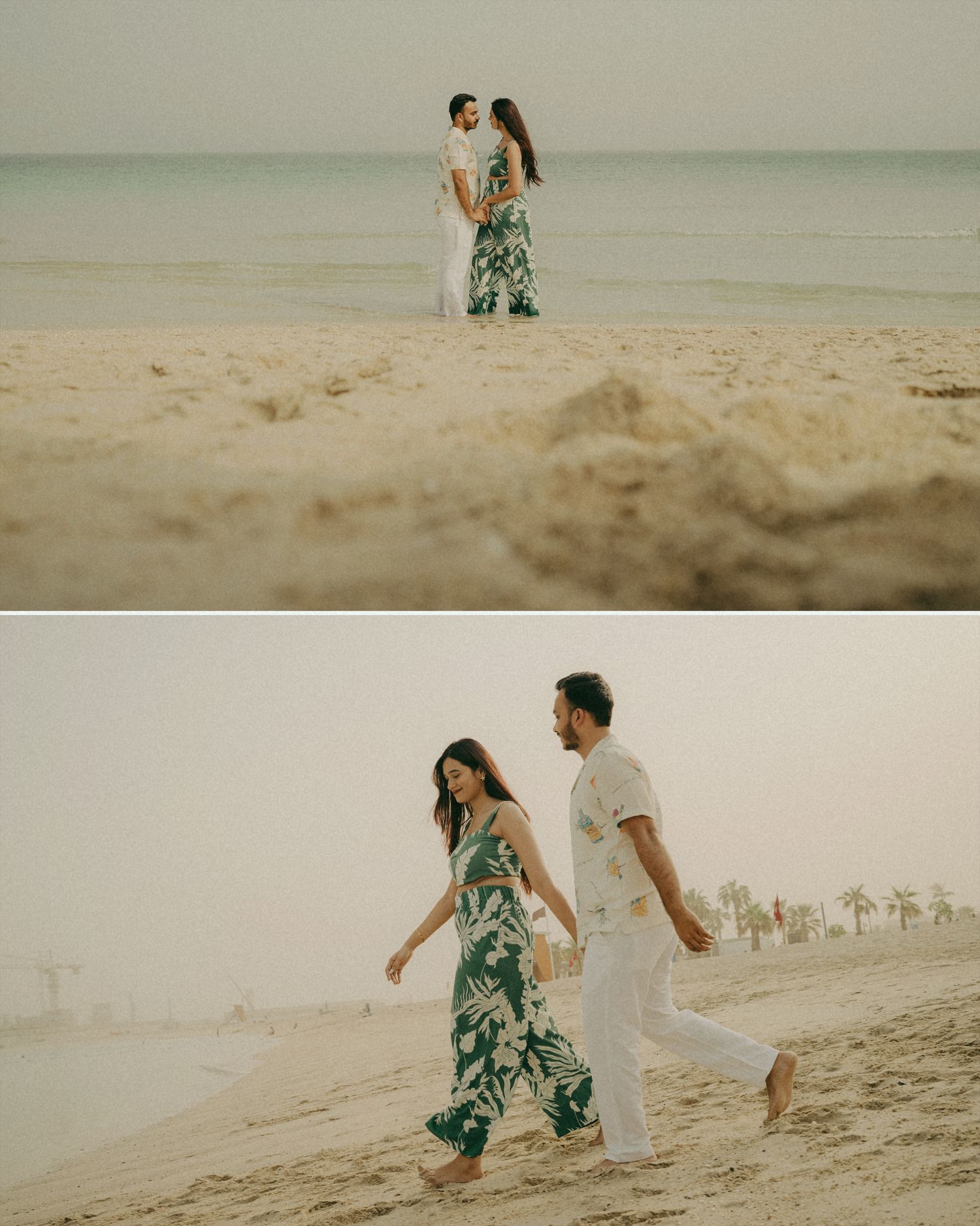 Couple walking hand in hand on a sandy beach, woman in tropical green jumpsuit, man in white outfit, palm trees in background.
