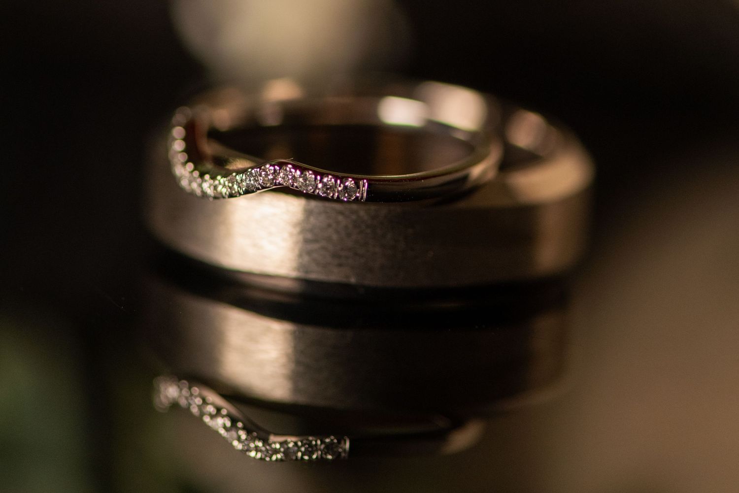 Macro photography of wedding rings with dramatic lighting and shallow depth of field. Whitney McLaren Photography