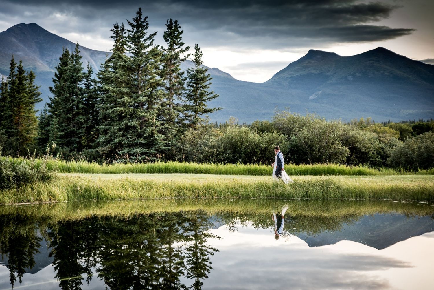 Dramatic mountain landscape reflected in still lake water at dusk. Whitney McLaren Photography