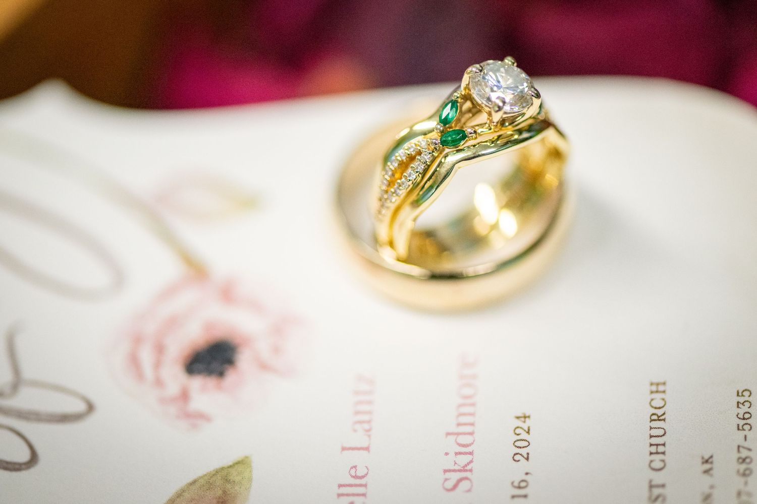 Close-up of elegant wedding rings with gemstones on white surface. Whitney McLaren Photography