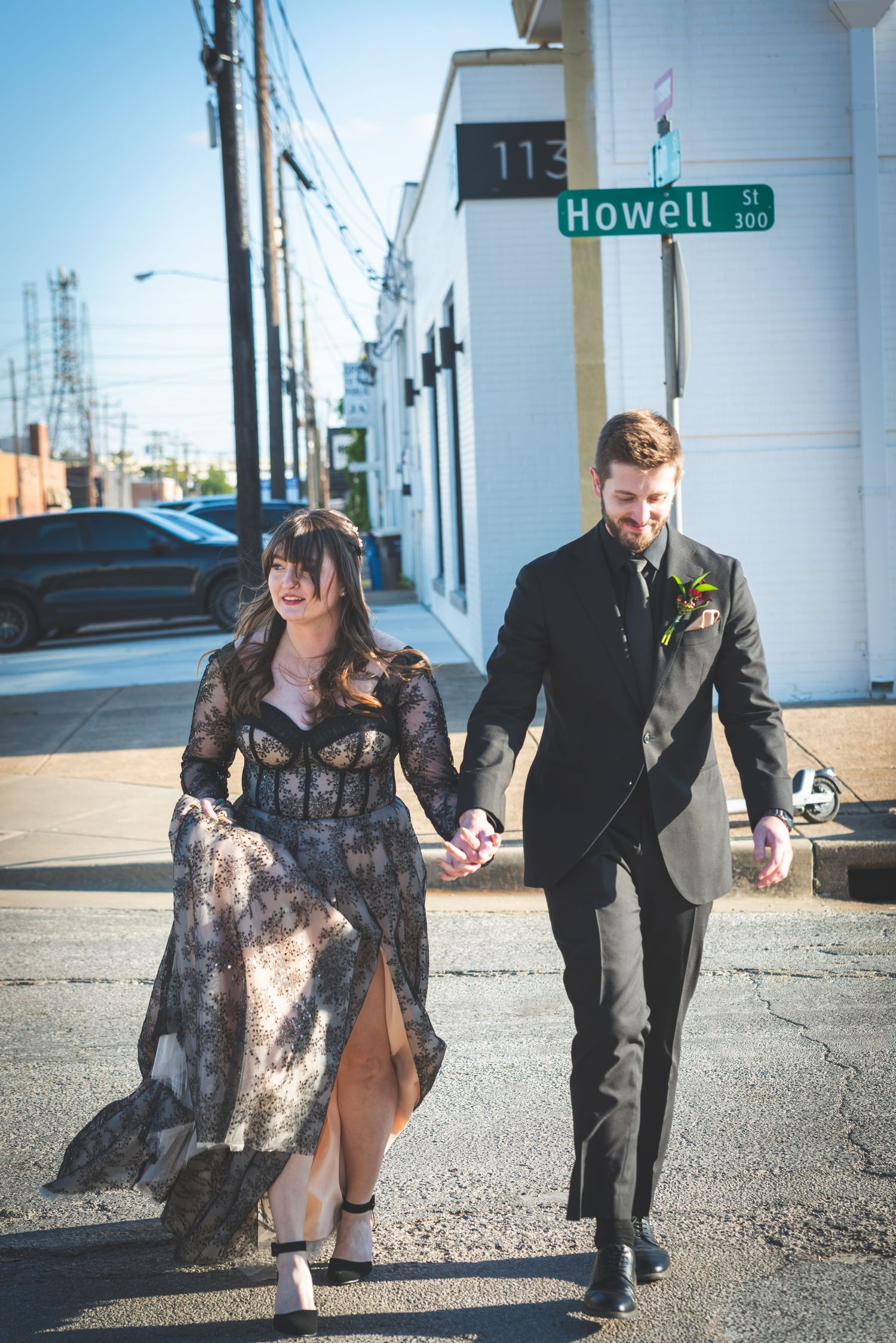 Couple walking together on urban street with Howell street sign visible. Whitney McLaren Photography