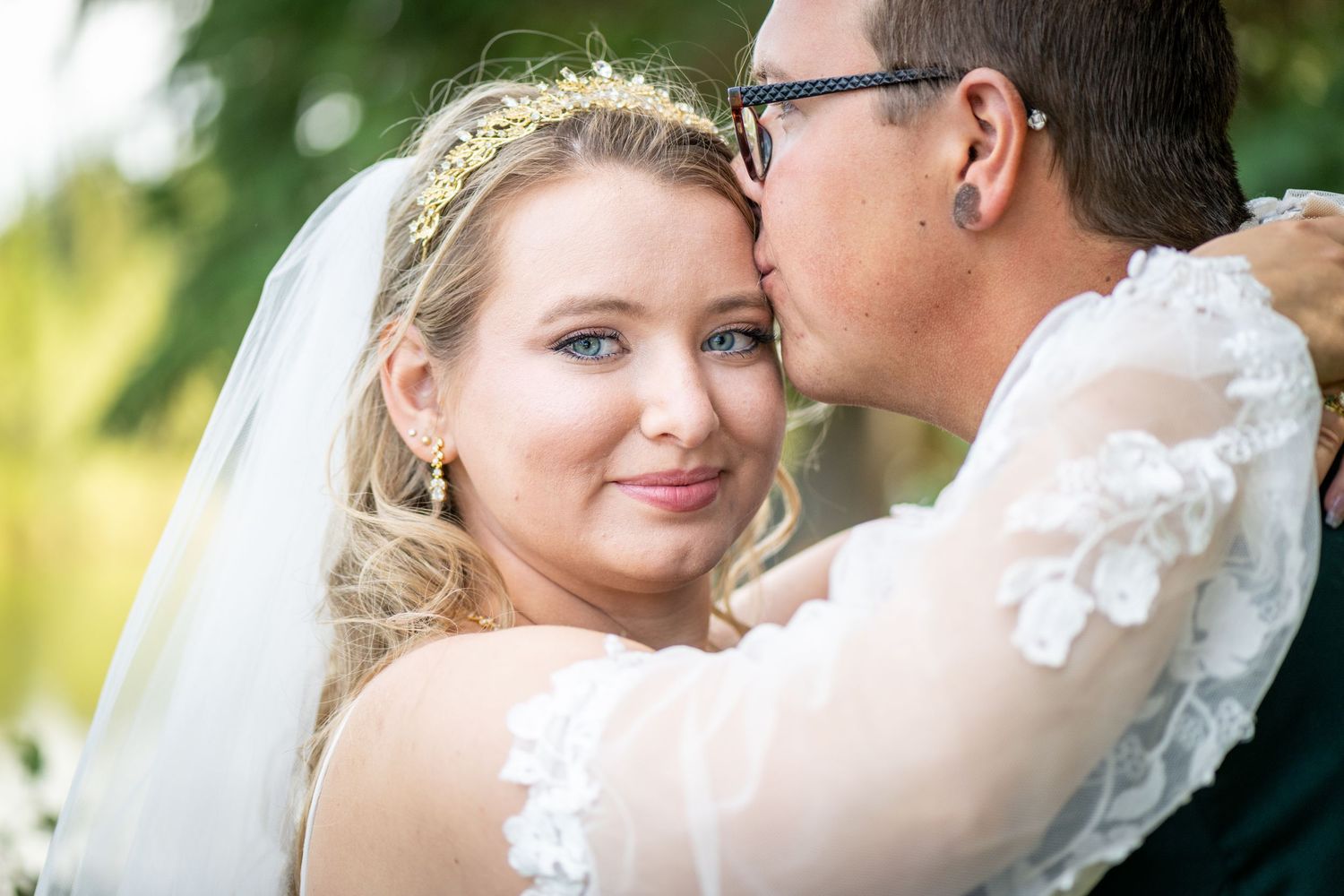 Romantic wedding couple embracing in soft sunlit outdoor setting. Whitney McLaren Photography