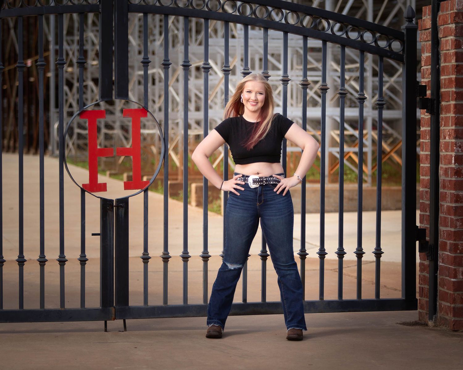 A split image showing a person in blue jeans posing in front of a black iron gate at different angles.