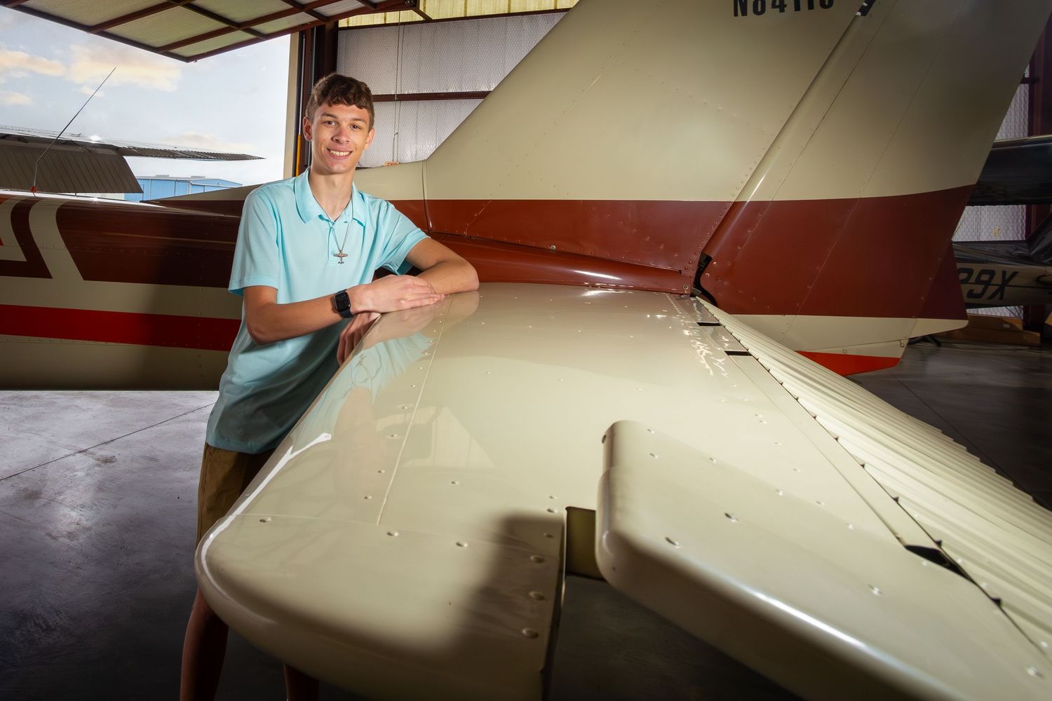 Skilled craftsperson working on detailed upholstery process for aircraft interior restoration in professional workshop.