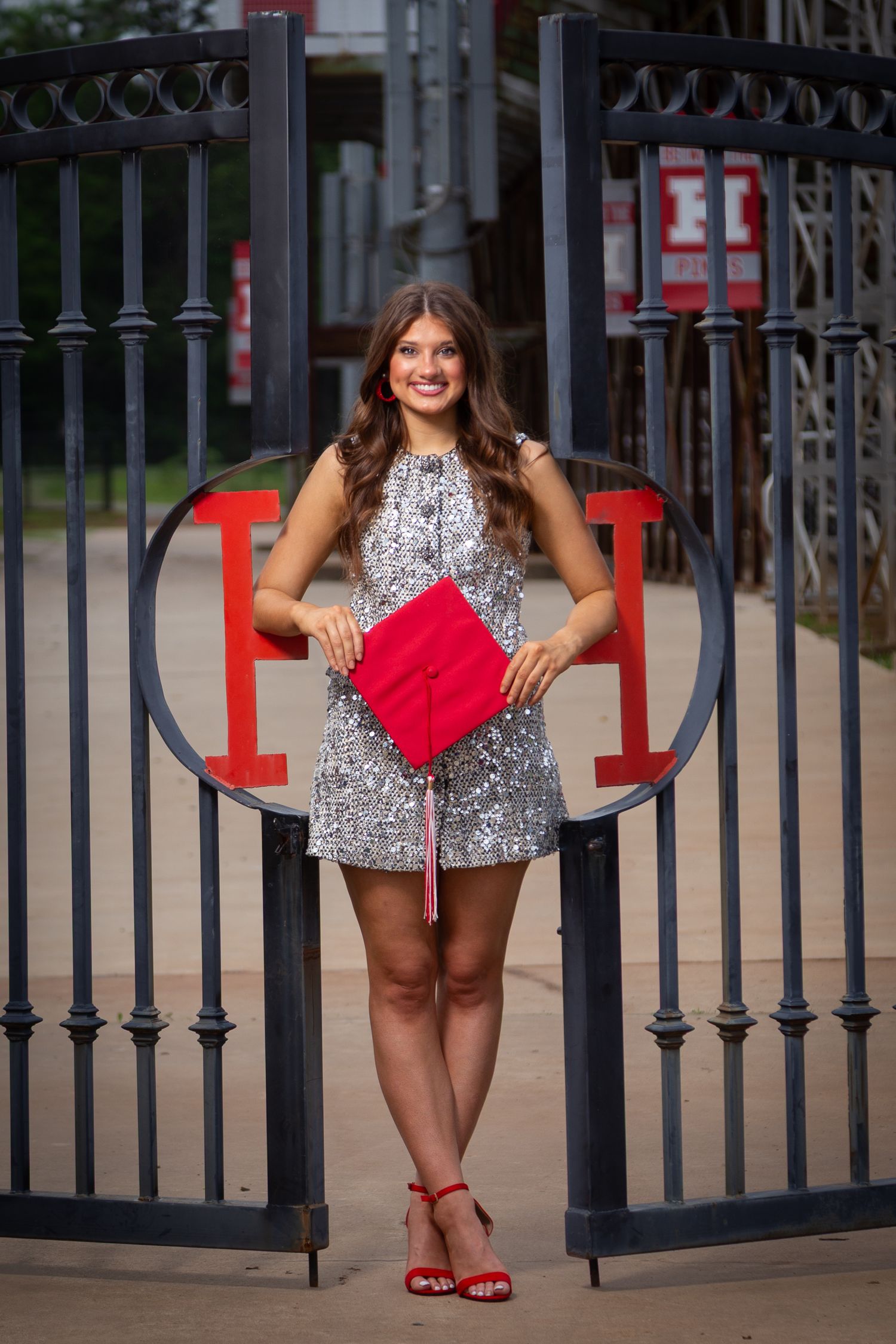 A collage of fashion poses against an iron gate featuring a silver sequin dress and red accessories.