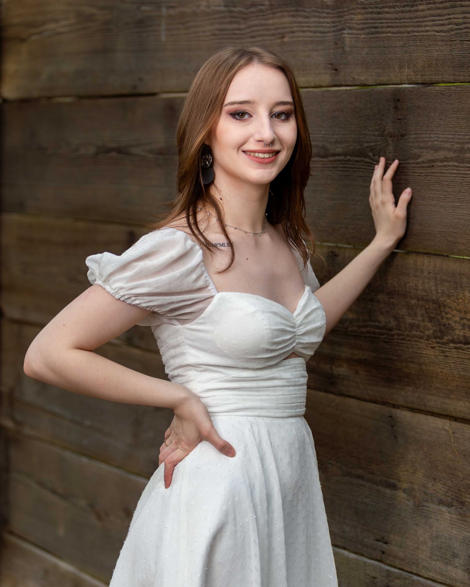 A series of photos showing a high school senior in a white dress posing against a rustic wooden wall background.