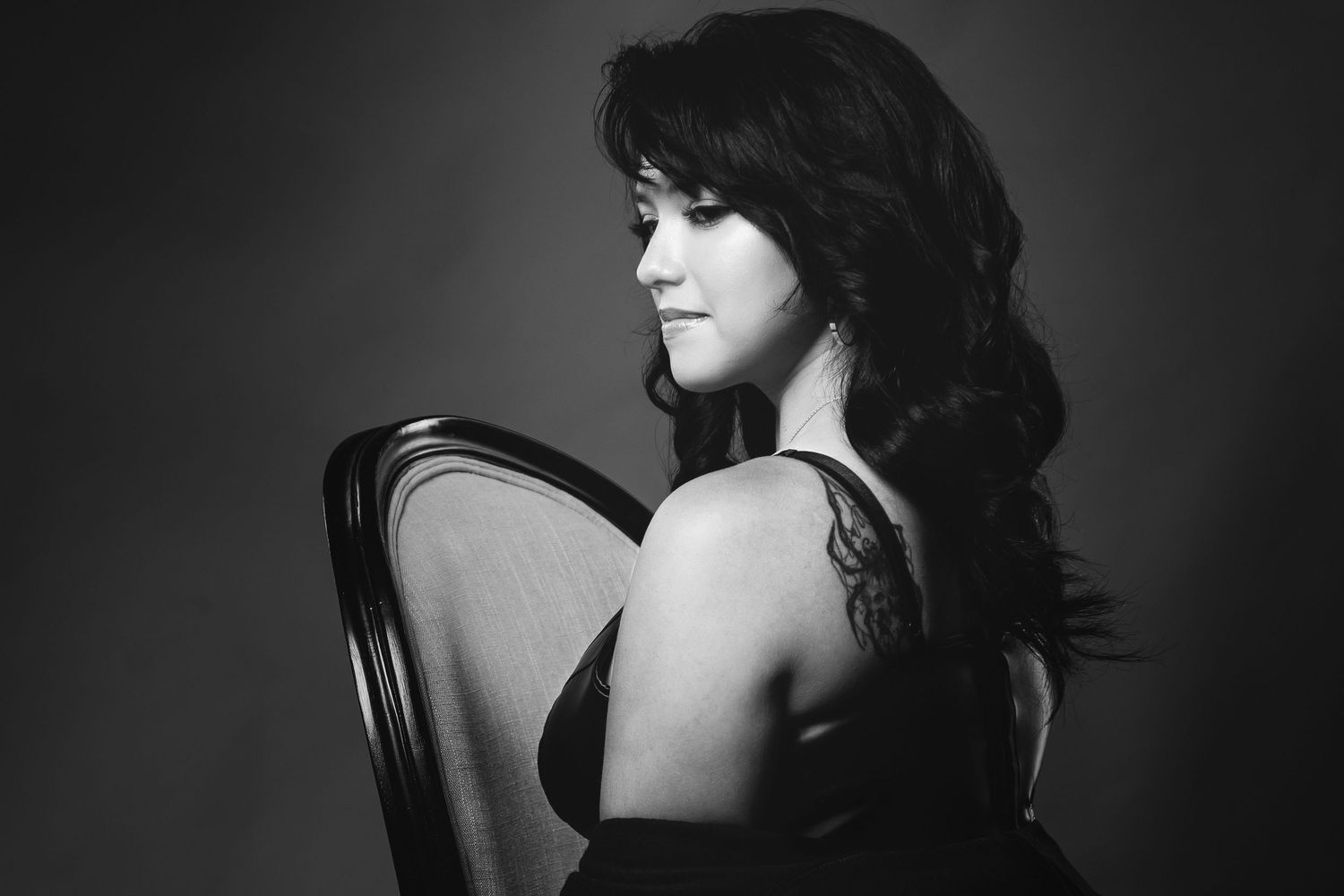 A black and white portrait series showing intimate angles of a woman in dramatic lighting and shadows.