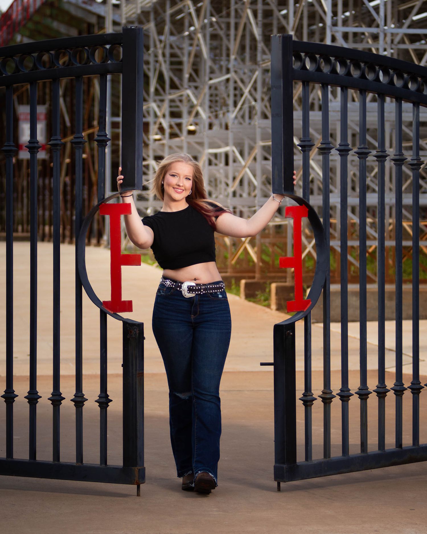 A series of portraits taken near decorative black metal gates and railings in an outdoor setting at sunset.