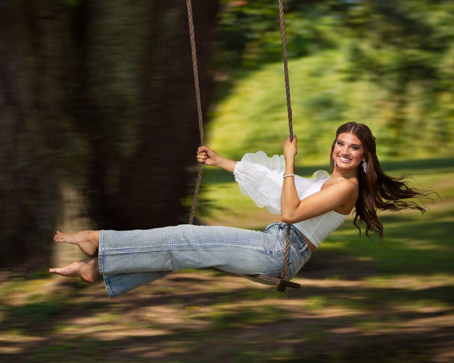 A sequence of motion shots showing someone swinging joyfully on a rope swing in a lush green forest setting.
