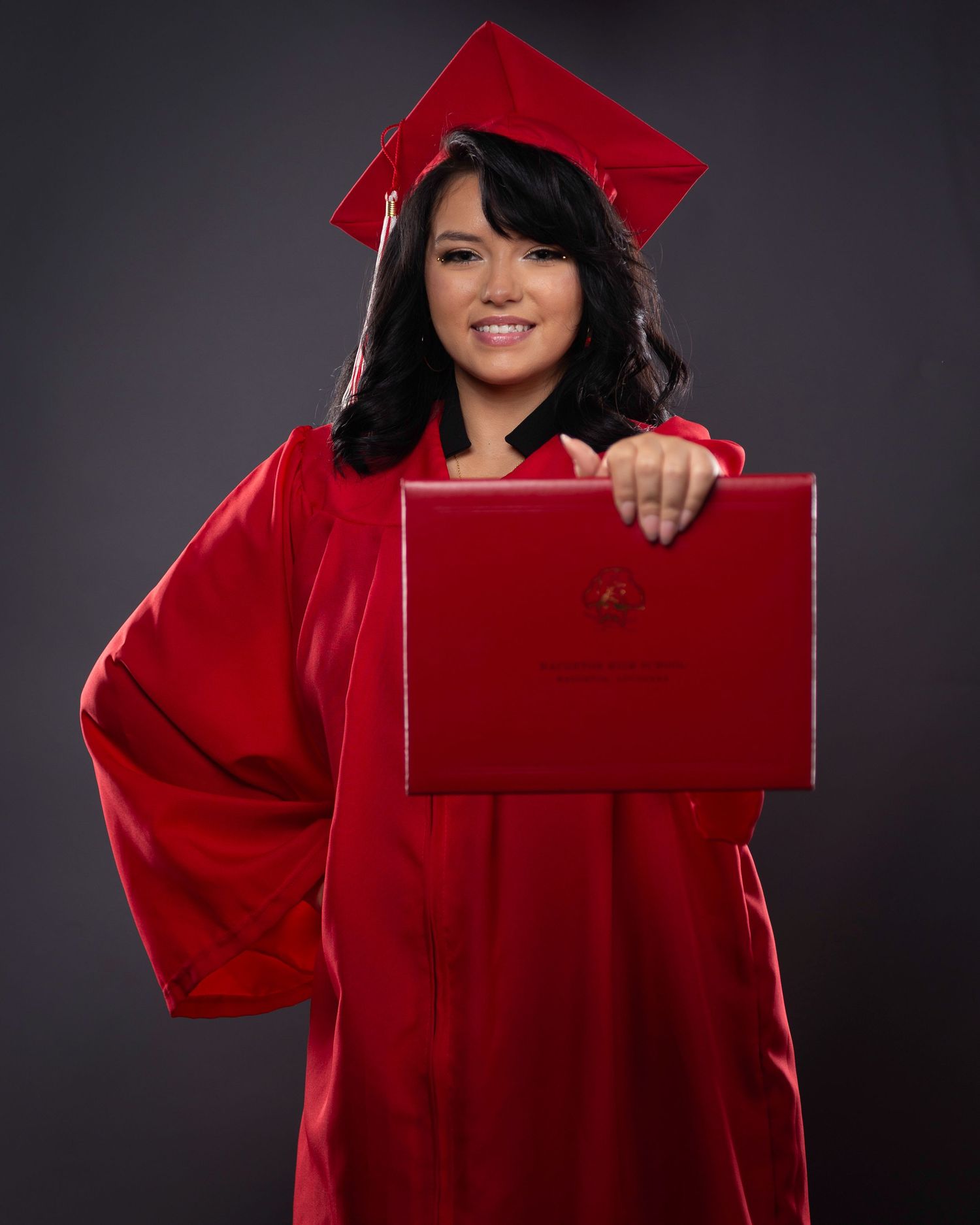 A graduate in red cap and gown poses for a series of celebratory portraits against a dark background.