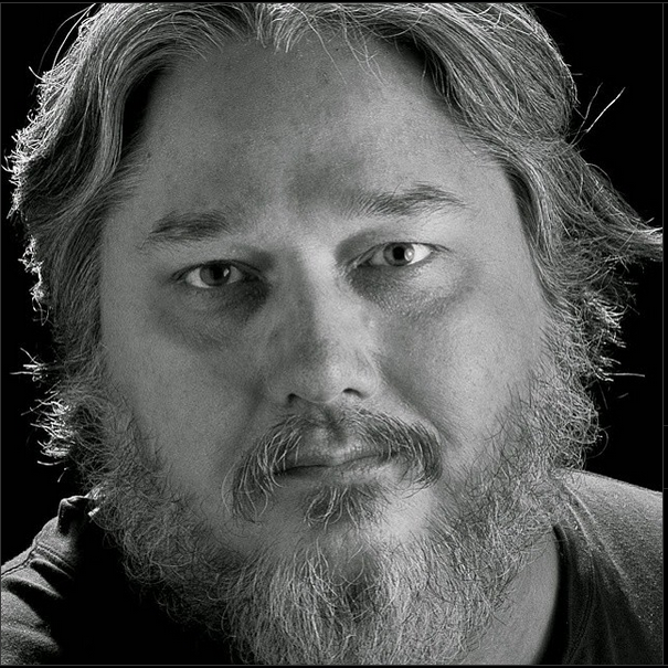 Black and white portrait series showing close-up views of a bearded man with long hair from different angles.