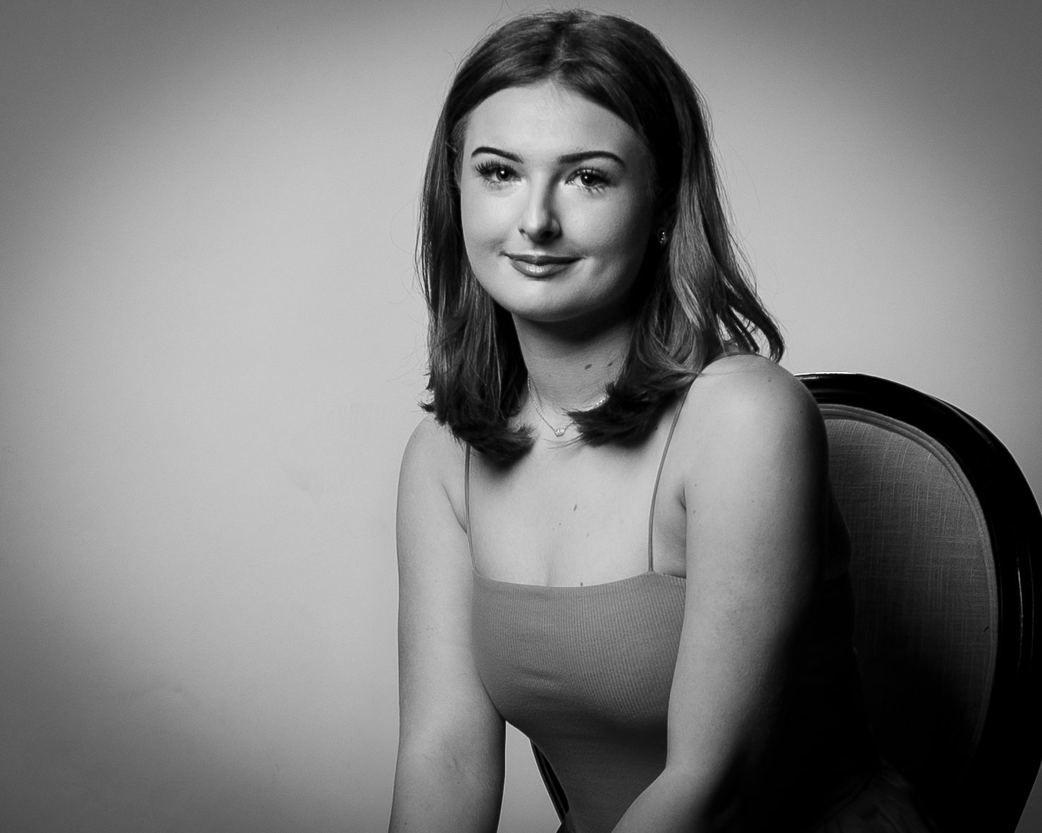 Black and white portrait series showing different poses and expressions against a simple background.