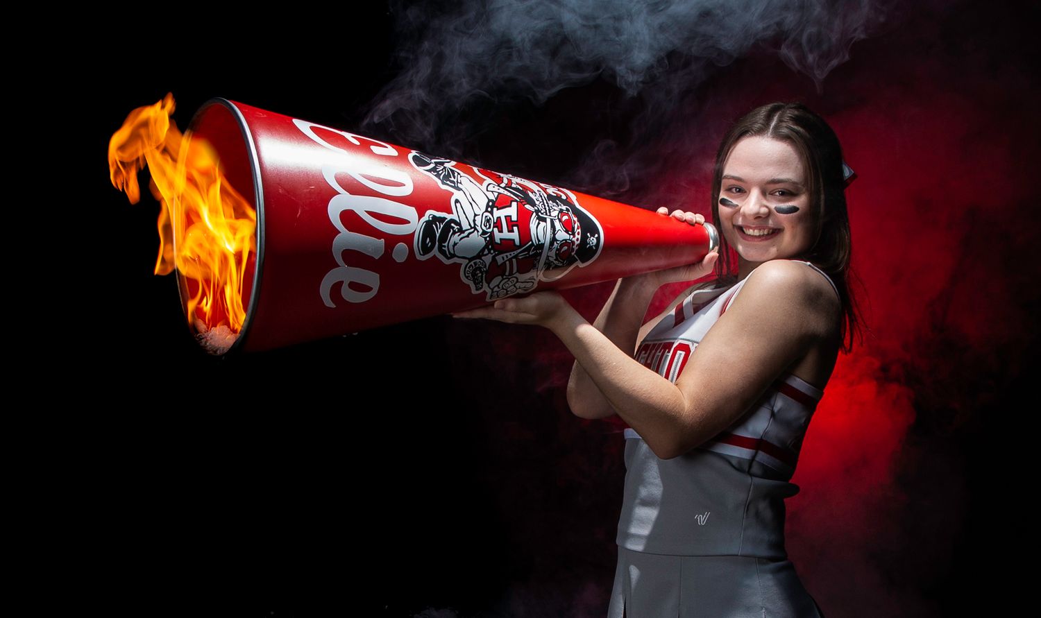 Dramatic sequence of someone drinking from a flaming Coca-Cola can against a dark red background.
