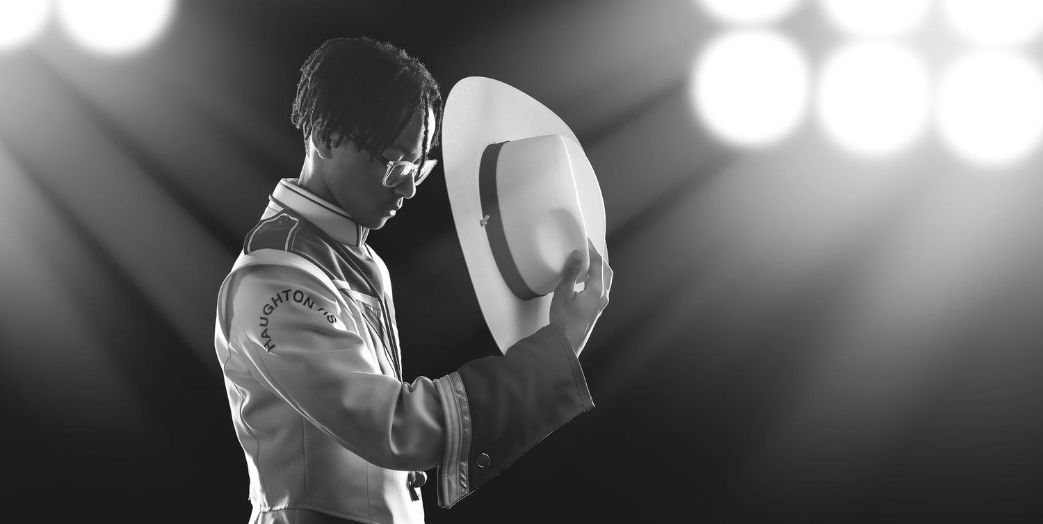 A black and white concert photo shows a performer singing passionately on stage with dramatic lighting effects.