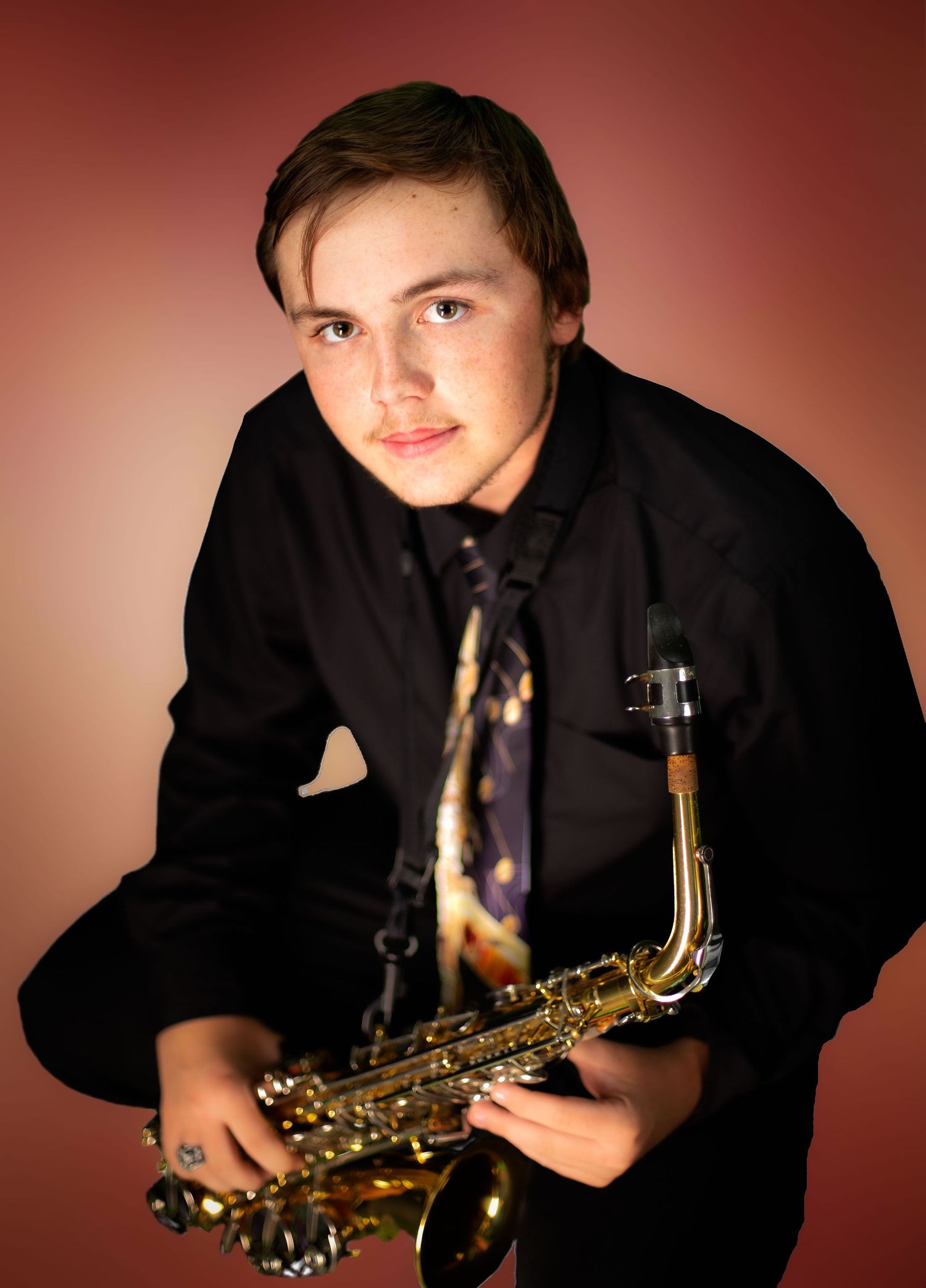 high school band member in black clothing performs on saxophone against dark red background in progressive motion sequence.