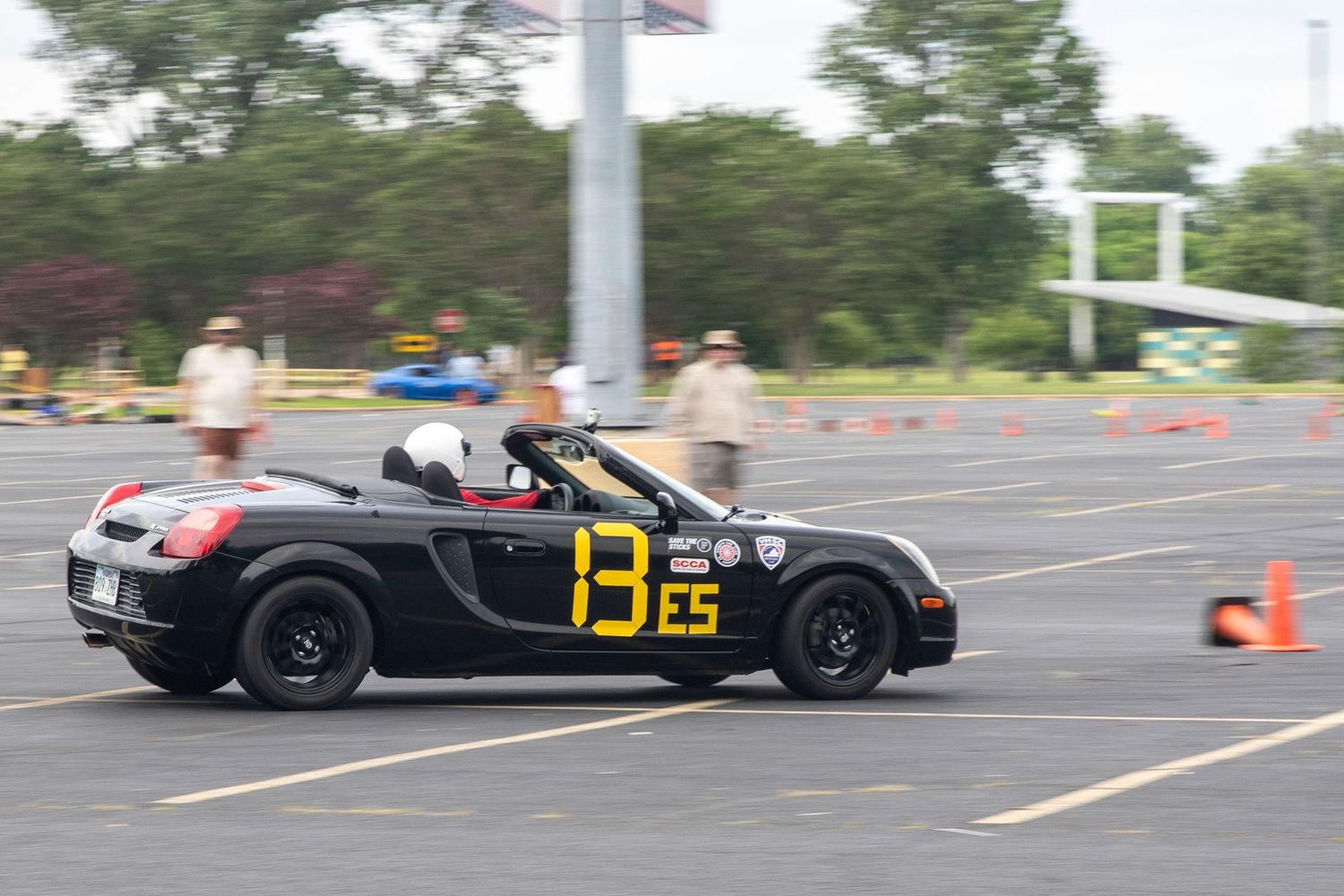 Black Toyota MR2 Spyder number 13 ES competing in an autocross race on a paved parking lot course.