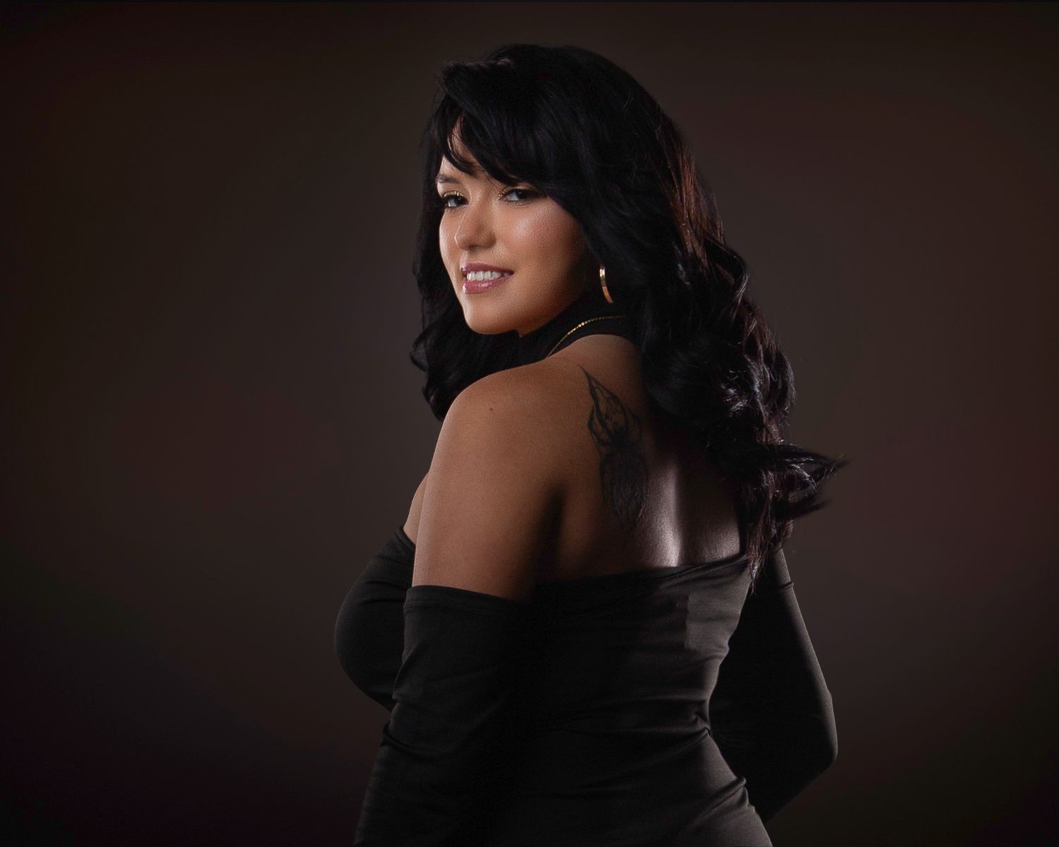 Professional studio portrait series showing a figure in a black outfit against a dark background with dramatic lighting.