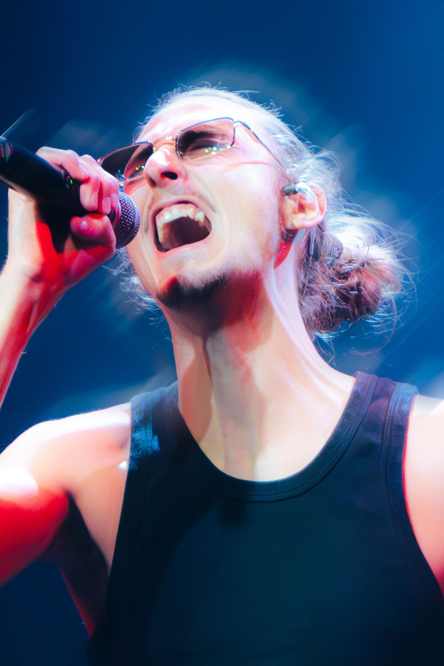 Dramatic sequence of a performer singing into a microphone against a blue-lit background with intense emotion.