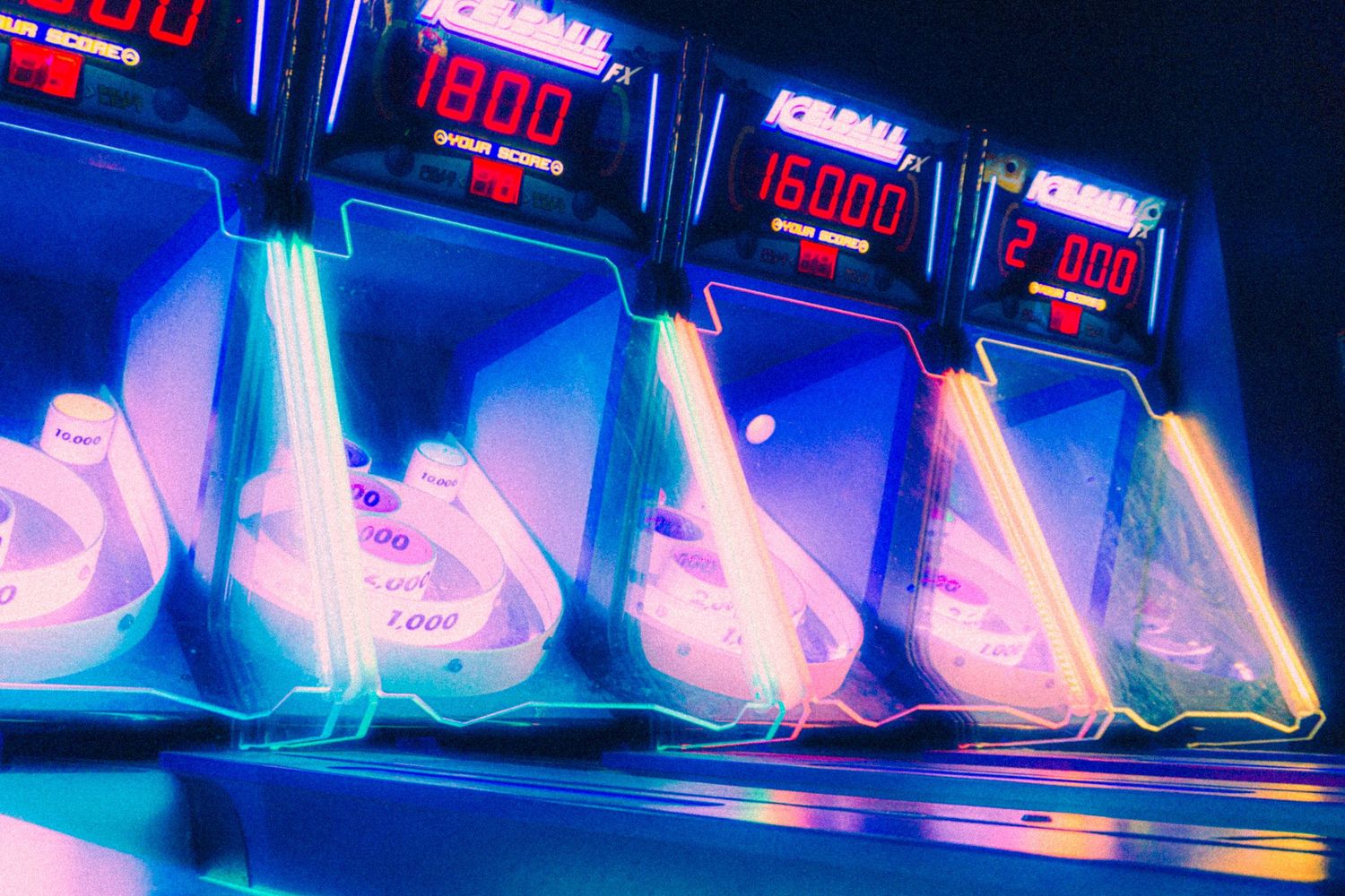 Neon blue and red LED lights illuminate a dark nightclub or bar setting with glowing signage and displays.