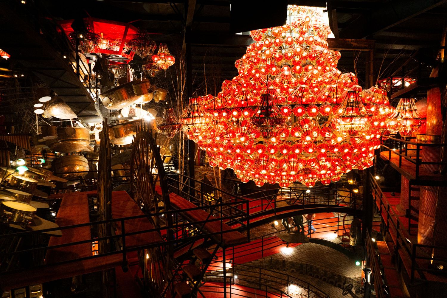 Red paper lanterns illuminate a dark restaurant interior creating a warm and festive Asian-inspired ambiance.