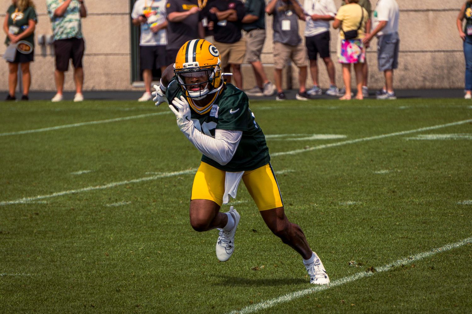 Football players in action during a game on a sunny field.