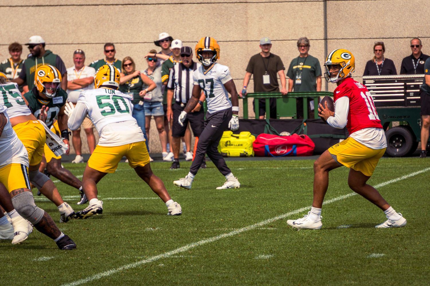 Football players line up at the line of scrimmage during a game with players in yellow and white uniforms.