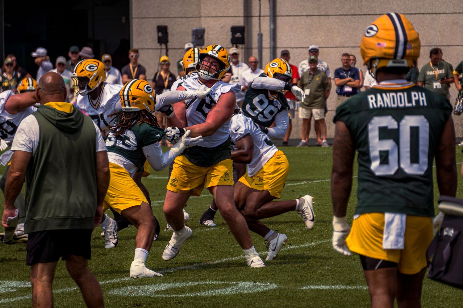 Packers offensive line players perform blocking drills during summer training camp practice session.