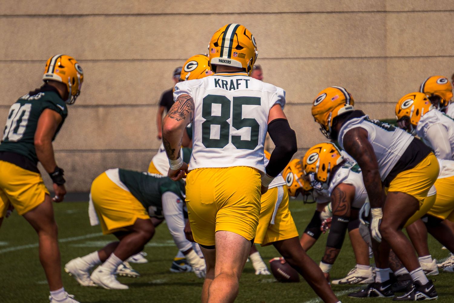 Green Bay Packers offensive and defensive lines square off during training camp practice on the football field.