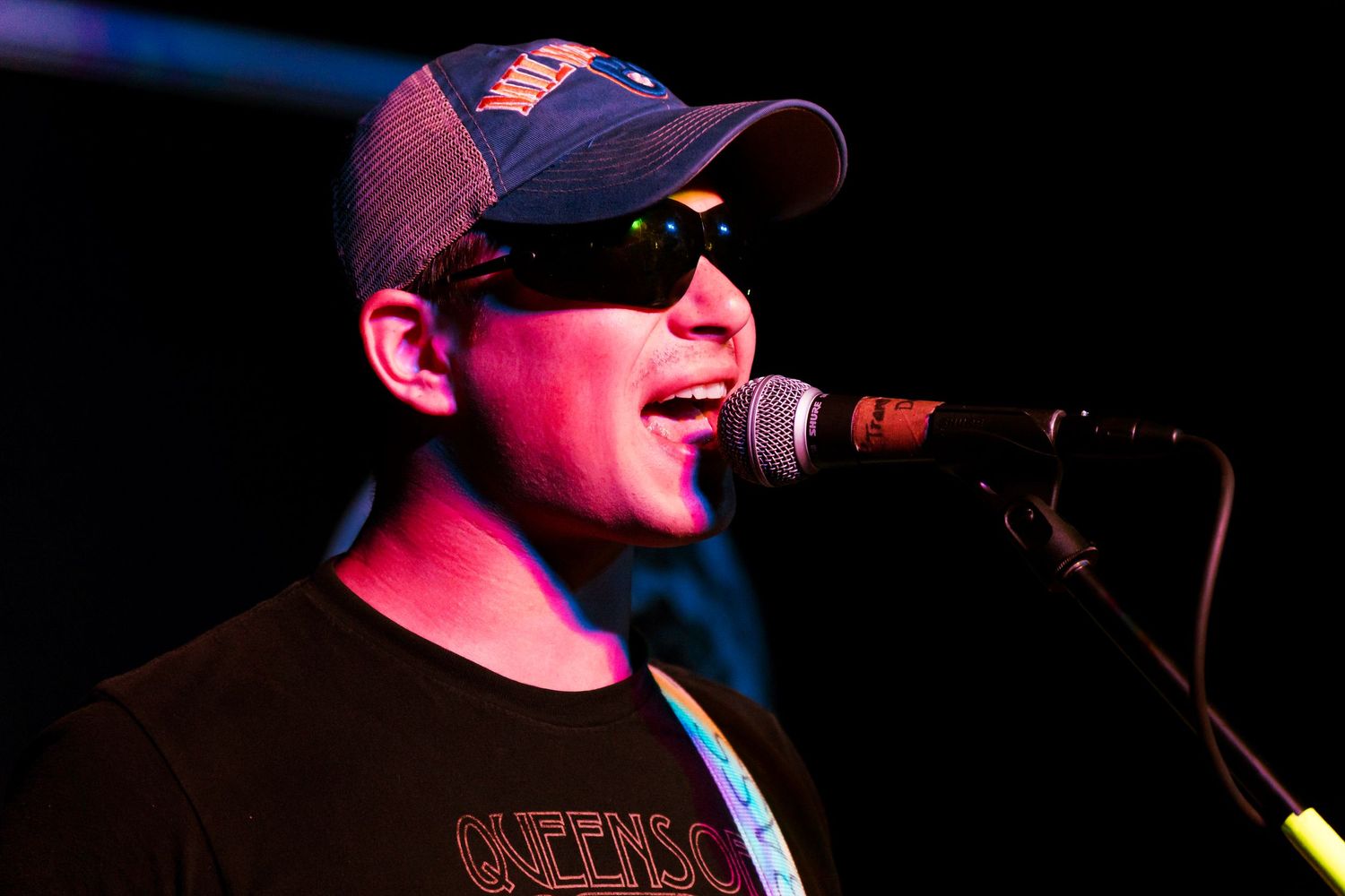 Concert performance scene with dramatic red and blue stage lighting.