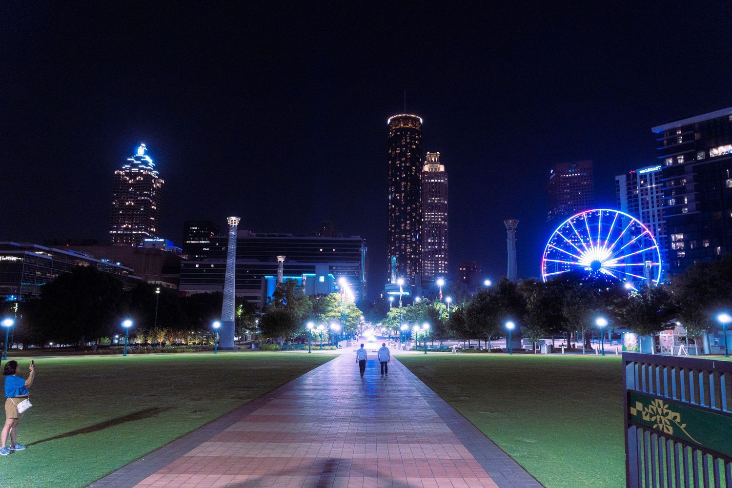 Atlanta skyline illuminated at night with the Ferris wheel and park paths visible in a panoramic view.