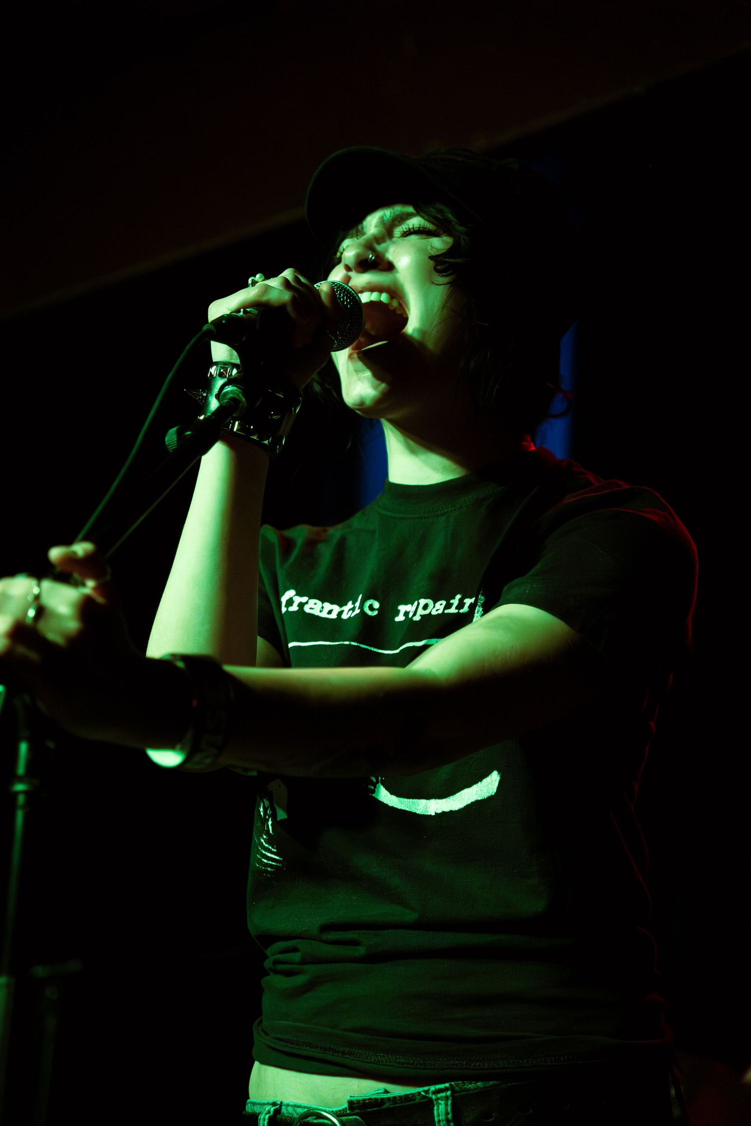 A series of dark concert photos showing performers in silhouette illuminated by green stage lighting.
