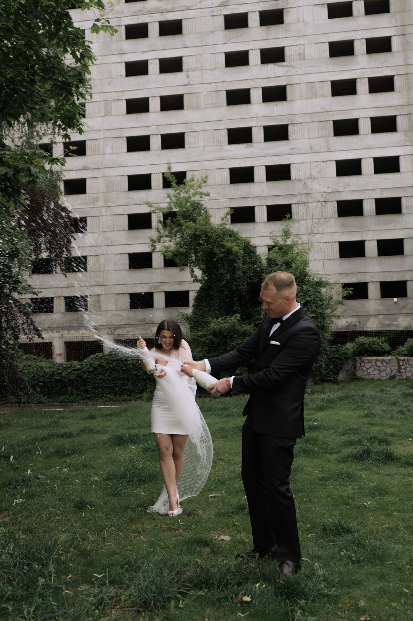 A series of dance poses captured against a concrete building backdrop showing graceful spins and movements in formal attire.