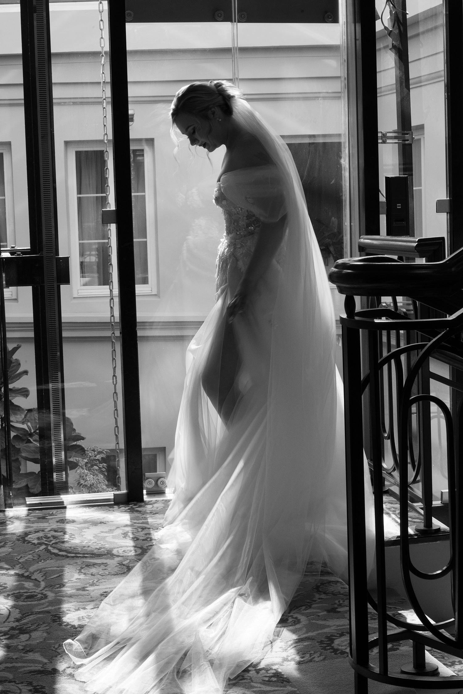A sequence of black and white photos showing a bride in a flowing white dress and veil walking through a doorway.