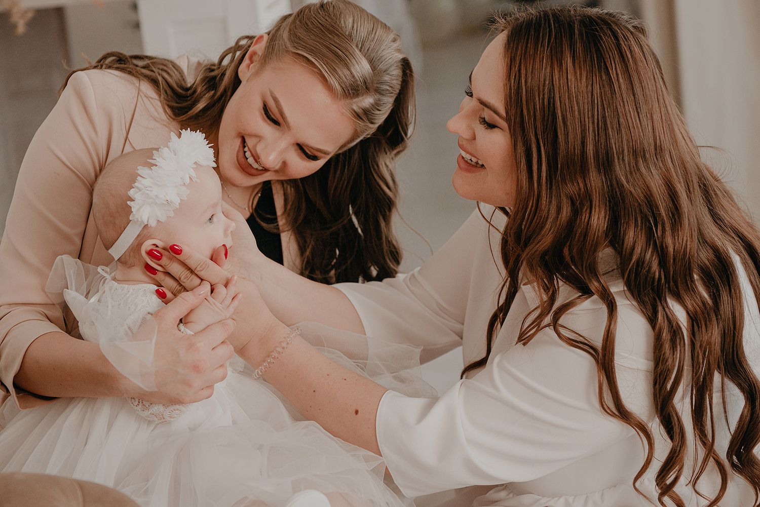 Mother and child share tender moments while playing together on white bedding in a series of lifestyle photos.